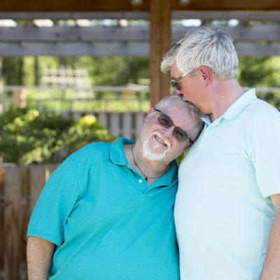 Detroit lgbt wedding - engagement session for same sex couple. Picture shown of two men holding each other while one is kissing the other on the head