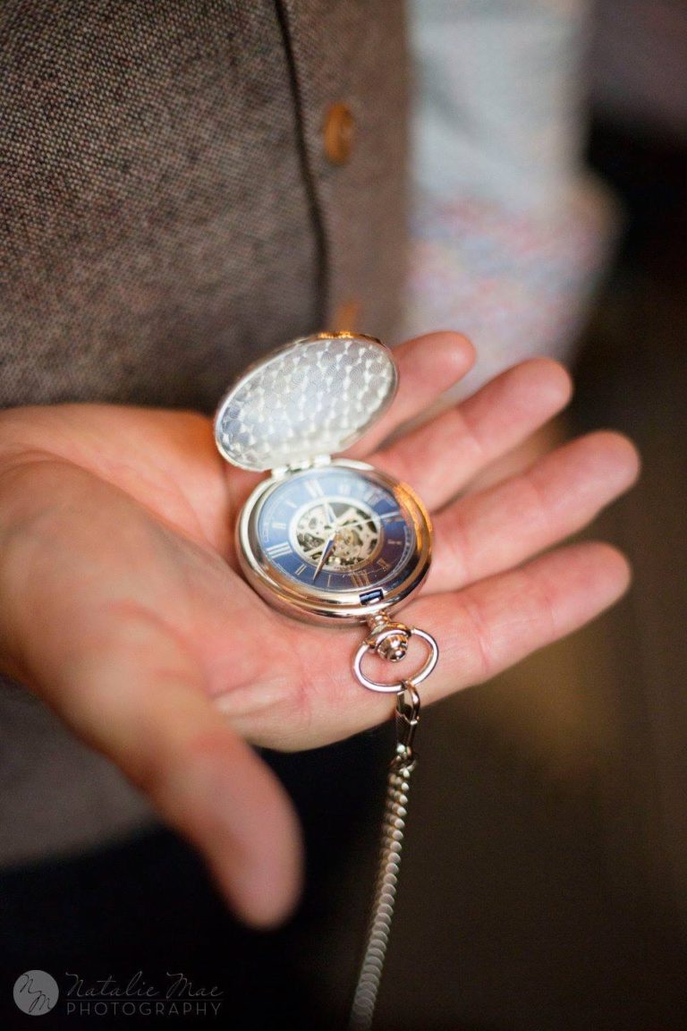 Groom holds compass similar to pocket watch - Michigan wedding photographer