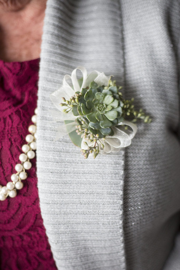 Succulent boutonnière on a gray sweater