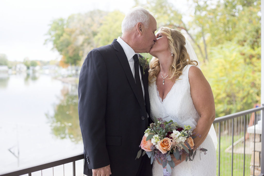 Couple kisses on the balcony of their Chelsea Michigan home