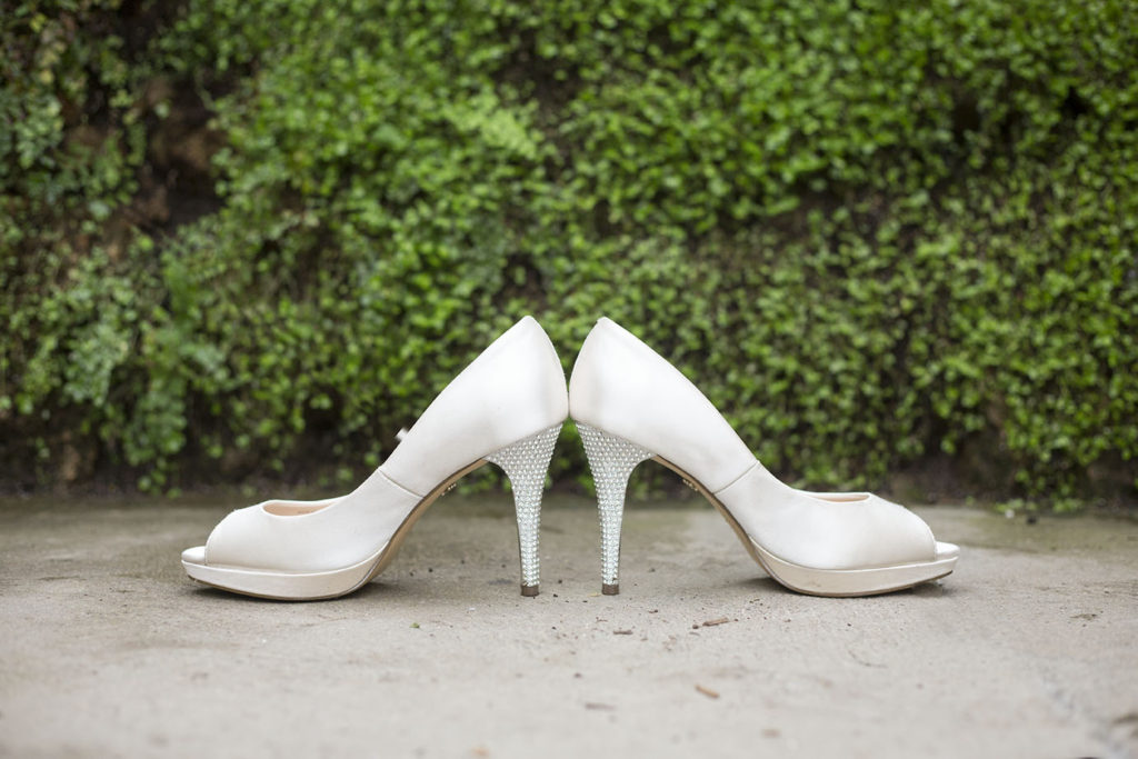 Wedding shoes in front of boxwood