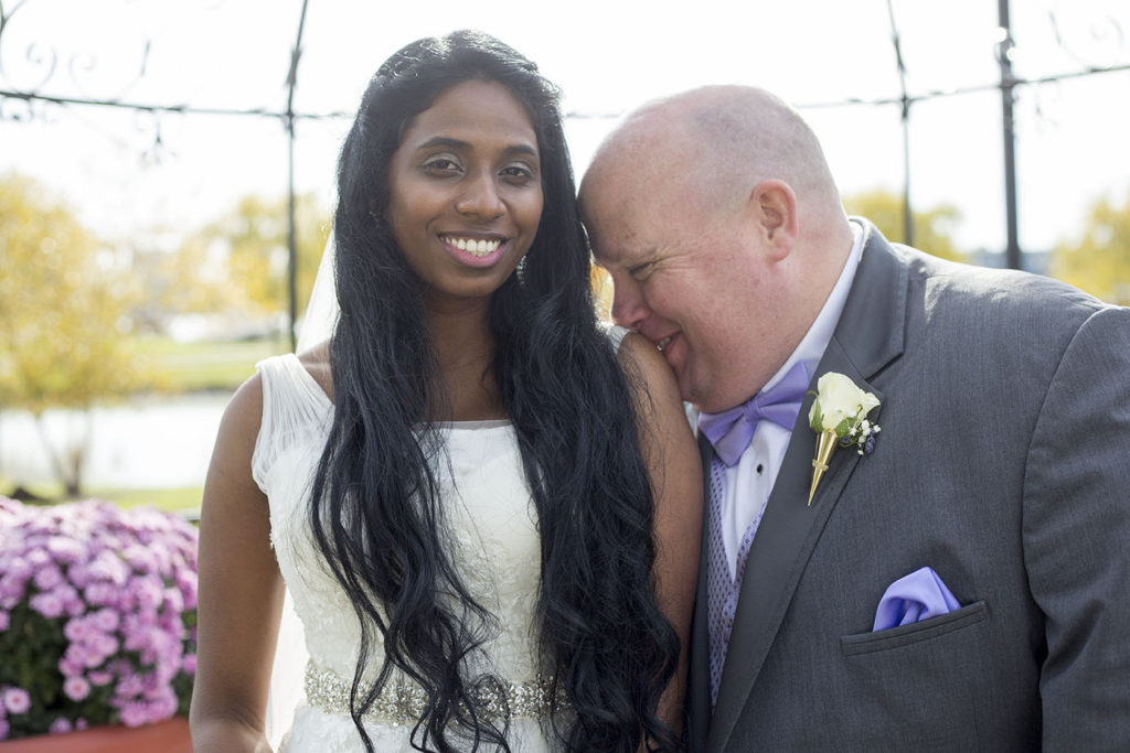 Groom kisses bride's shoulder under gazebo on Belle Isle