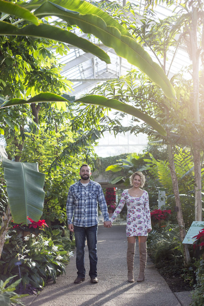 Couple-hold-hands-in-the-tropical-house