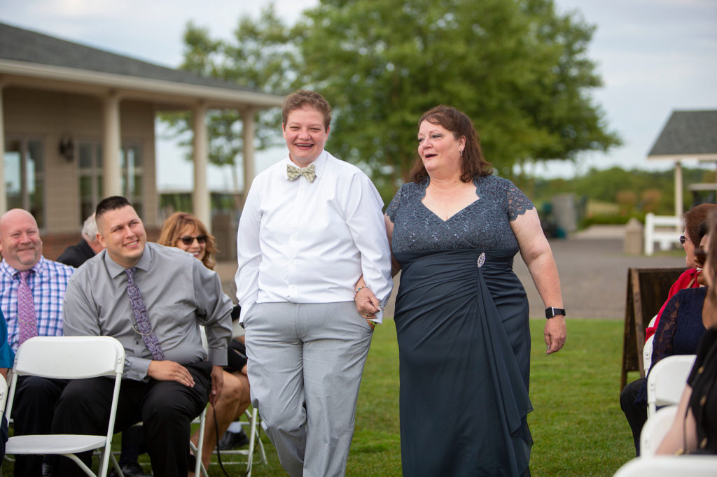 Daughter and mother share a laugh walking down the aisle