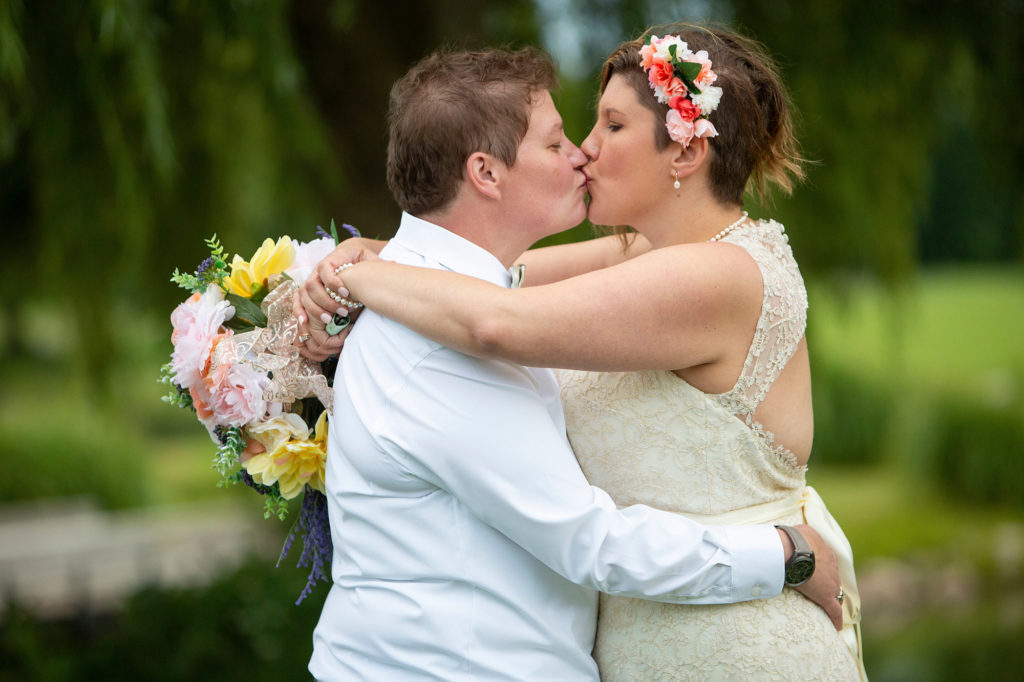 Cheryl and Emily kissing by the pond at the Links of Novi