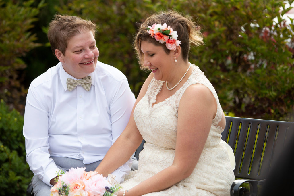 Michigan lesbian wedding couple sit together outside after their first look