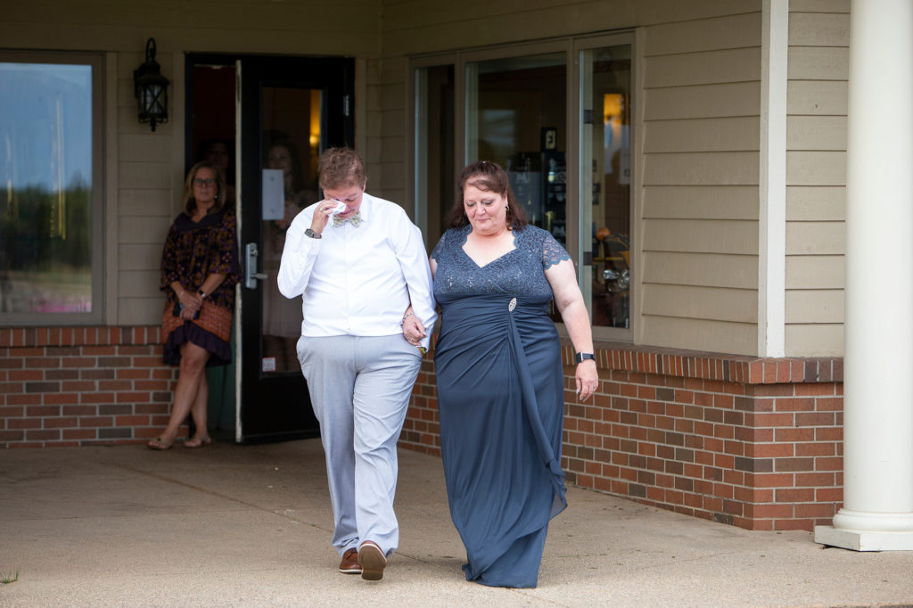 Cheryl and her mom walking down the aisle at her outdoor Michigan wedding