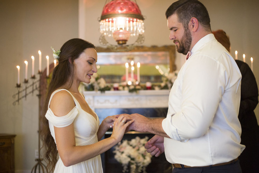 Bride putting ring on groom