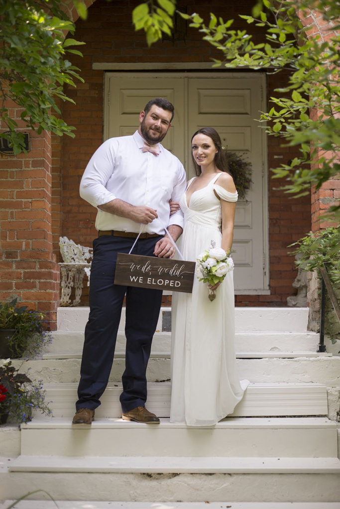 Couple poses in front of Celebrations Wedding Chapel