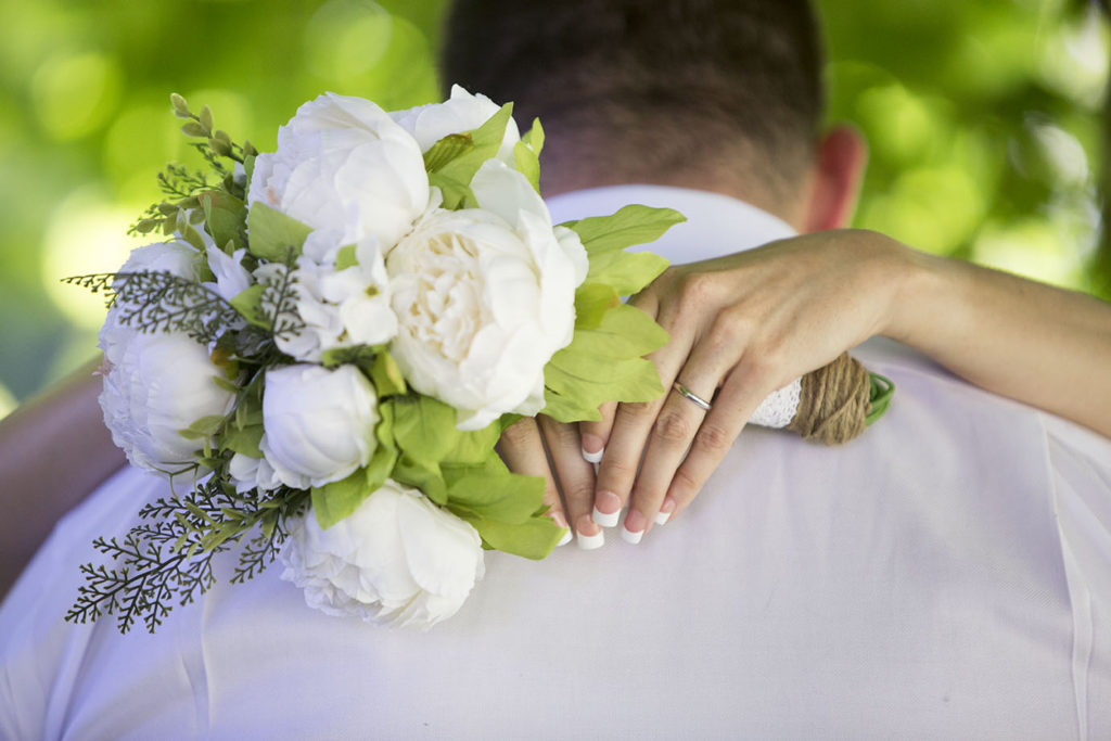 Bride wraps her arms around the groom's shoulders