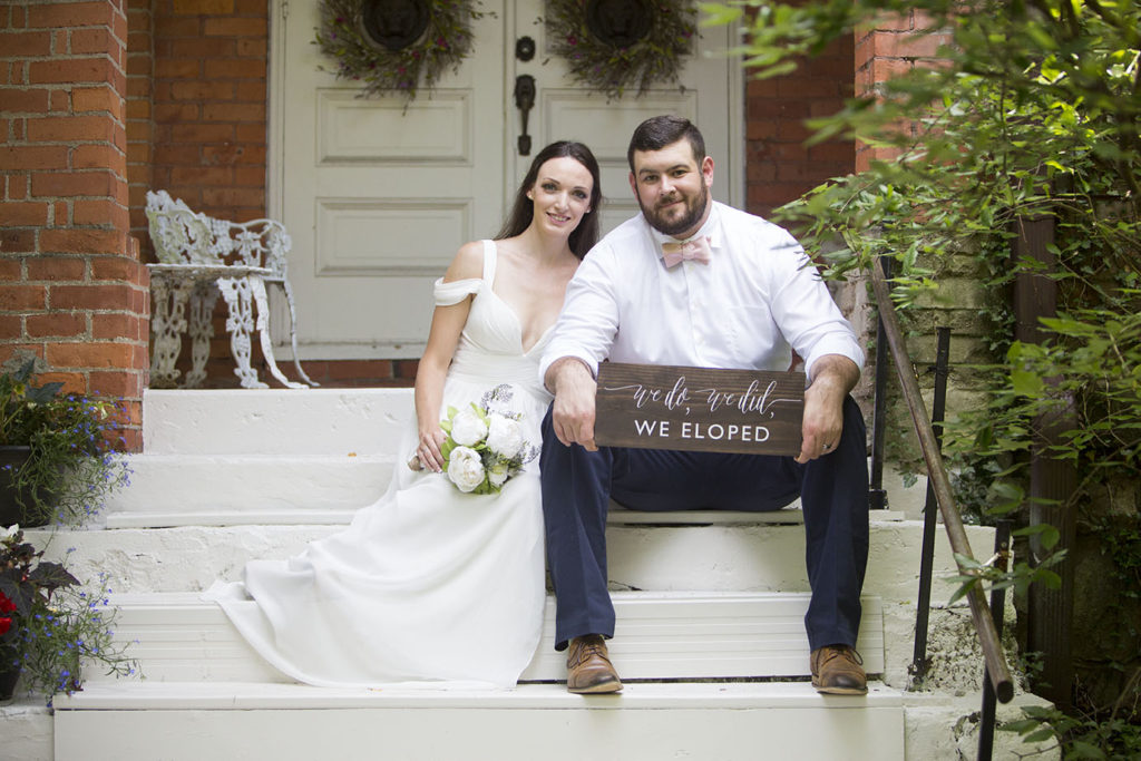 Michigan wedding couple sits on steps outside of chapel in Horton Michigan