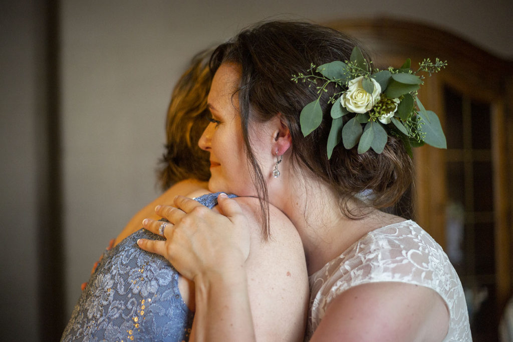 Mother hugging daughter before her Northville wedding