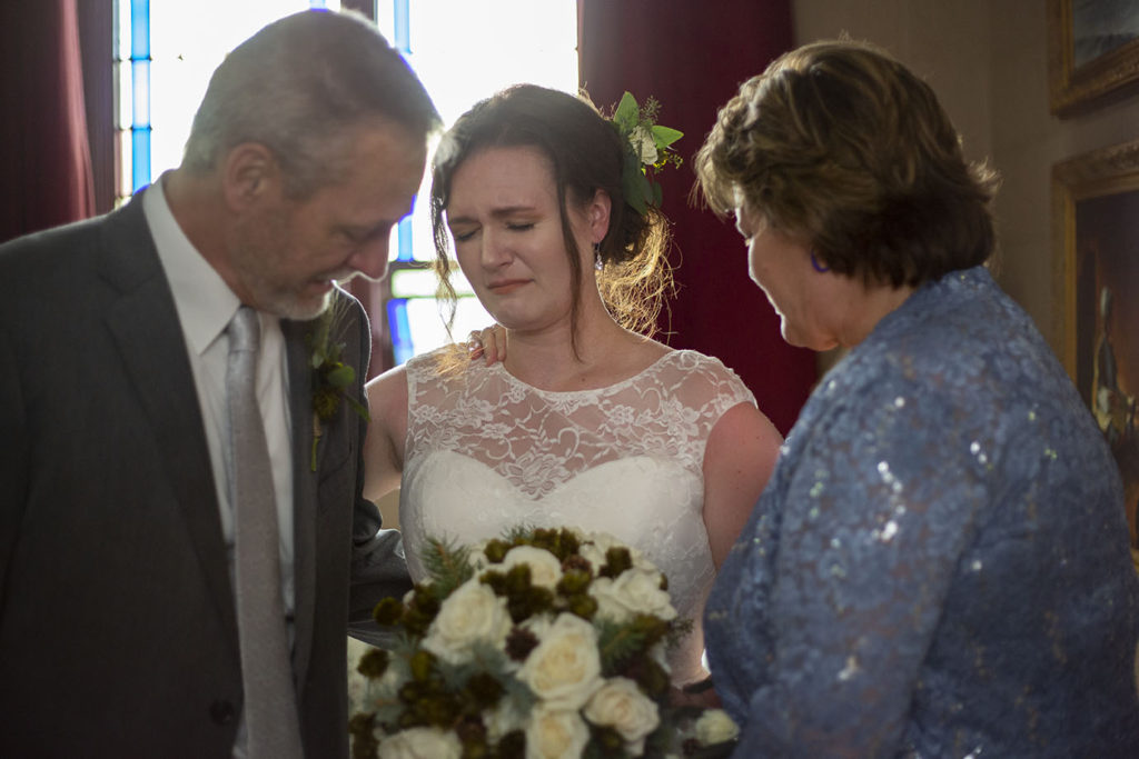 Rachel and her parents praying before walking down the aisle