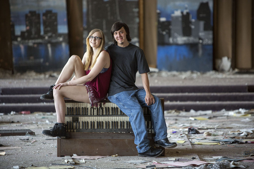 Detroit engaged couple sits on top of dilapidated piano