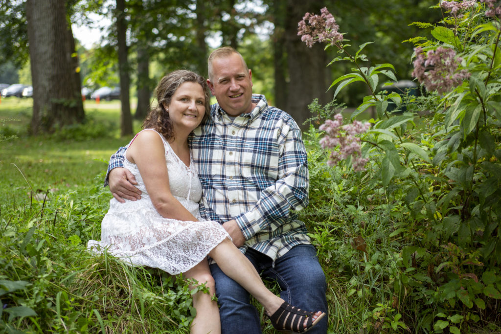 The couple cuddles up next to a creek leading to the Huron River in Dexter