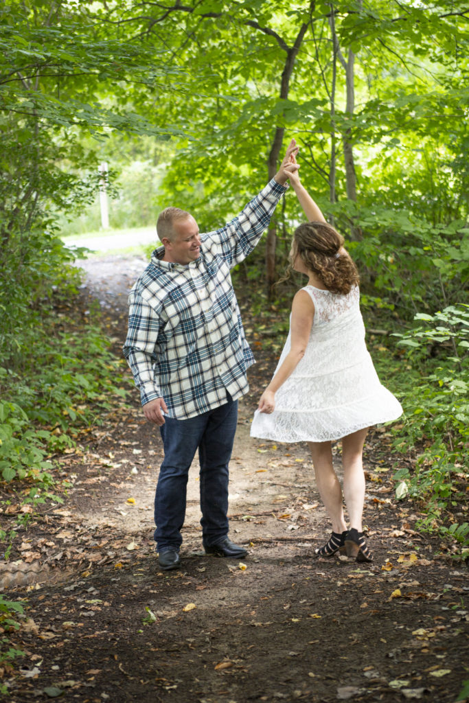 Chris twirls Lola on a path in the forest