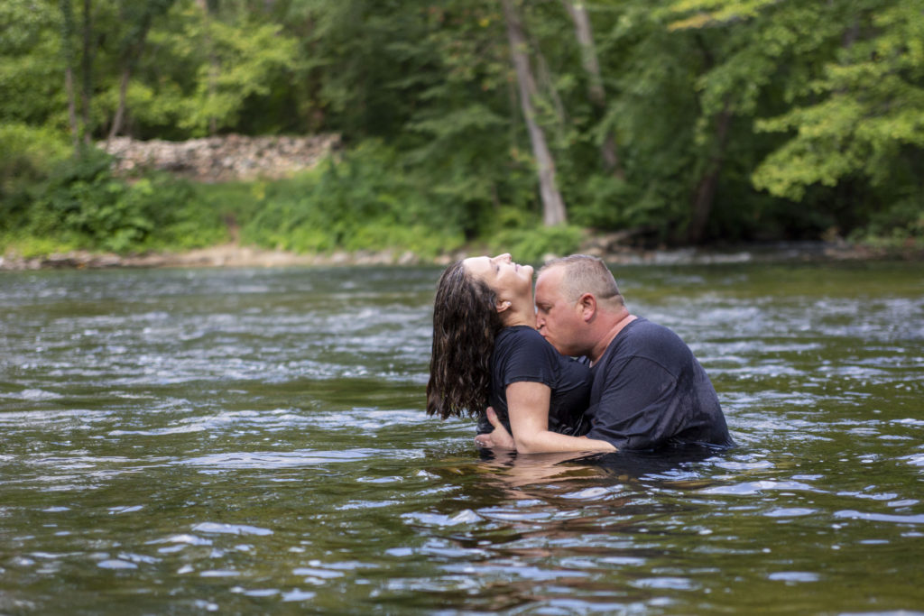 Couple kisses in the river during their Dexter engagement session