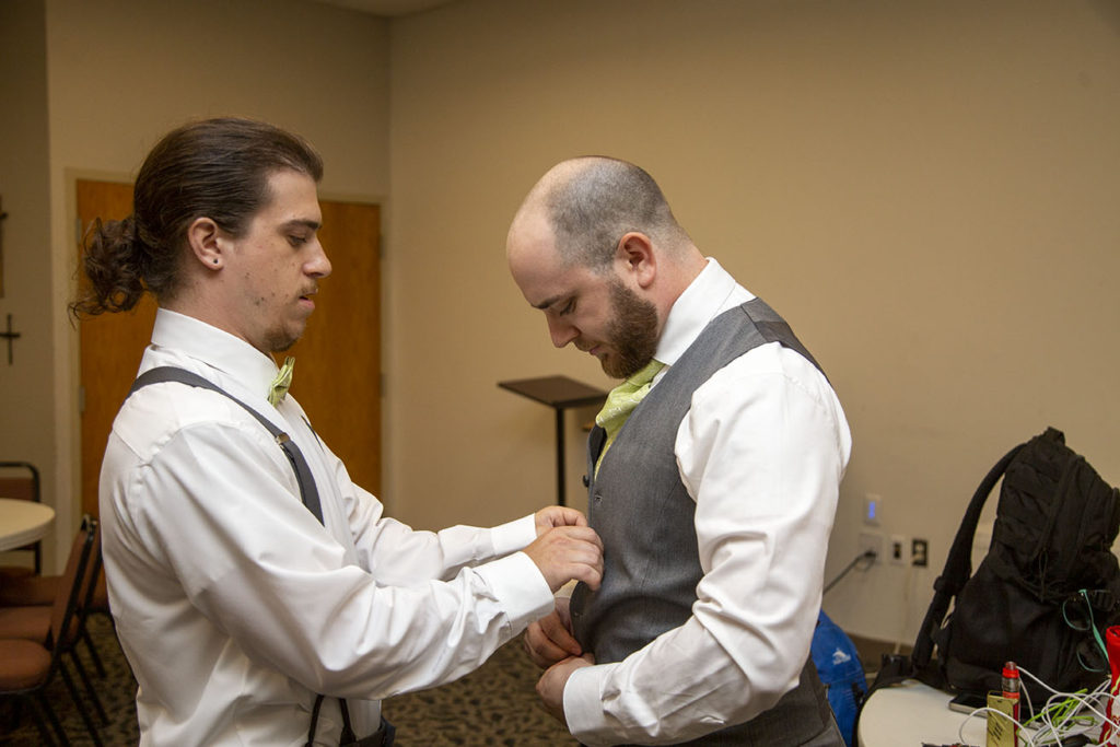 Best man helping the groom get ready