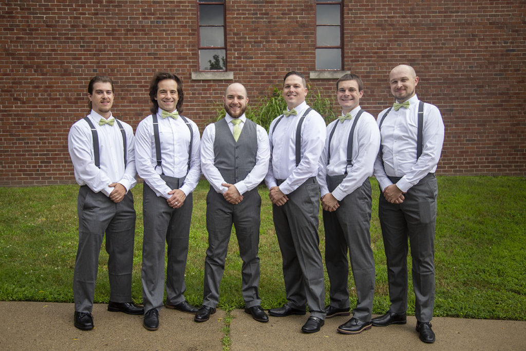 Groomsmen stand together outside the church