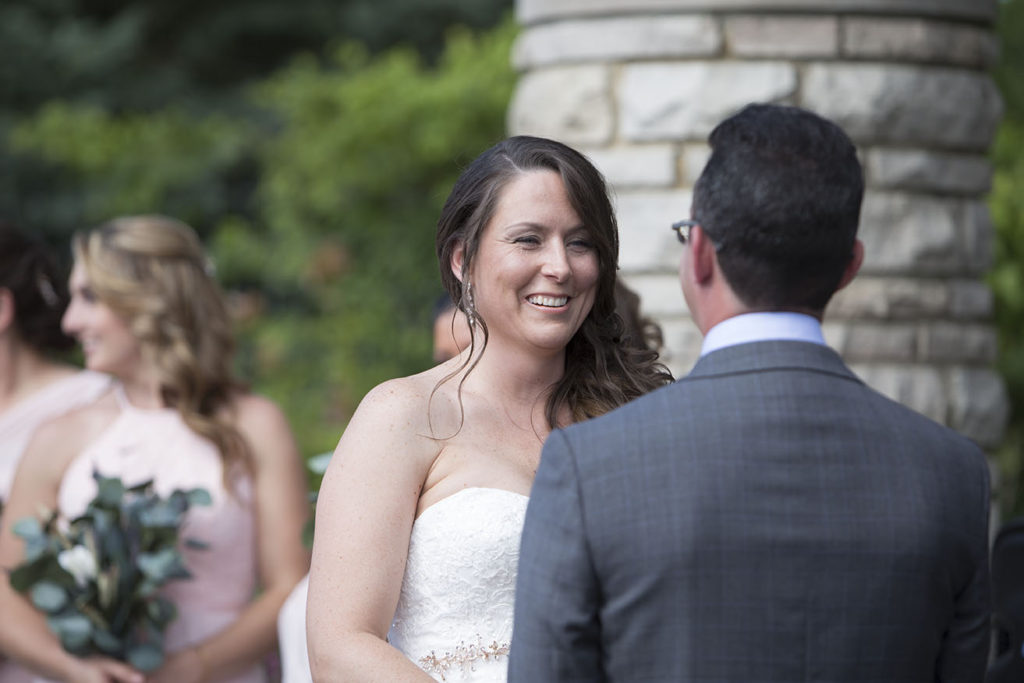 Amanda smiling as she exchanges vows with Mark at their Ann Arbor wedding.