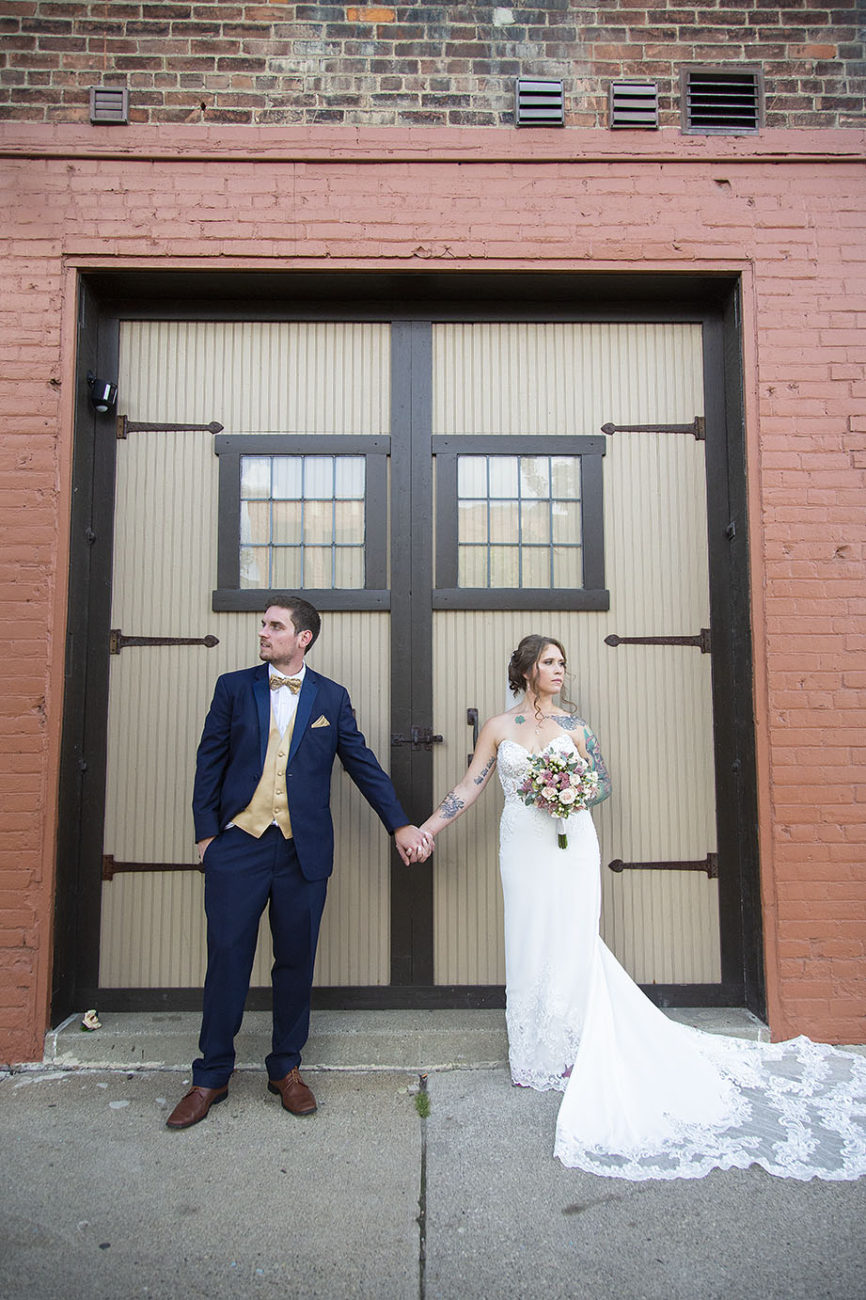 Howell wedding couple poses in front of large doors