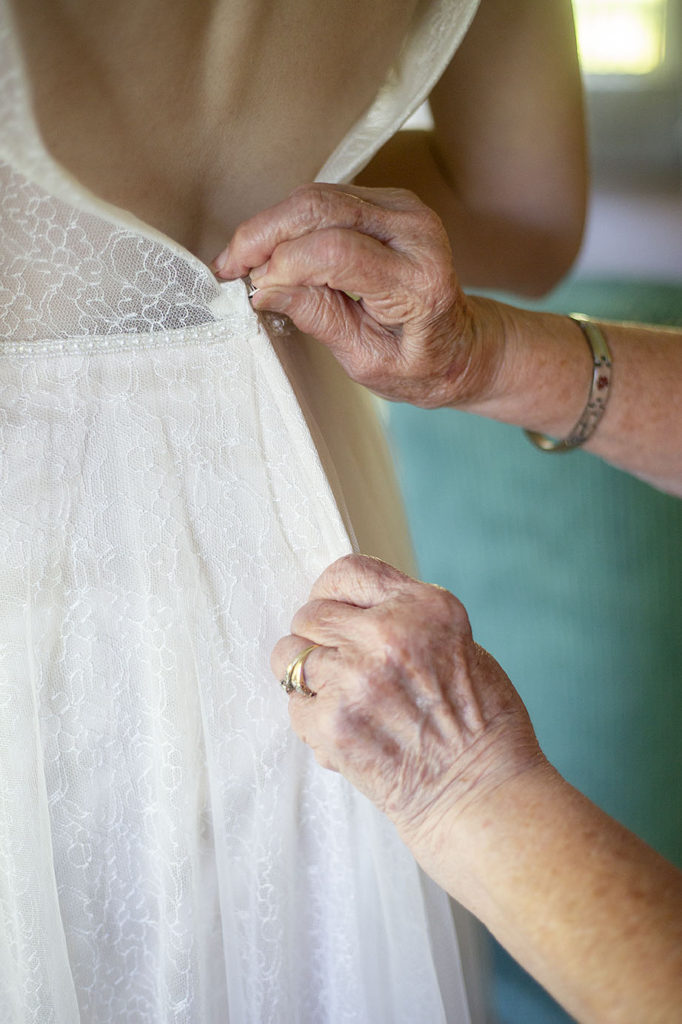 Grandma zipping bride's dress