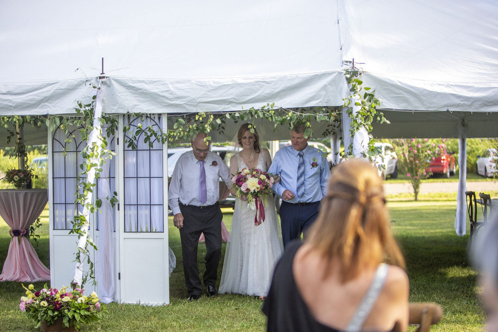 Bride emerging from tent at Belleville wedding