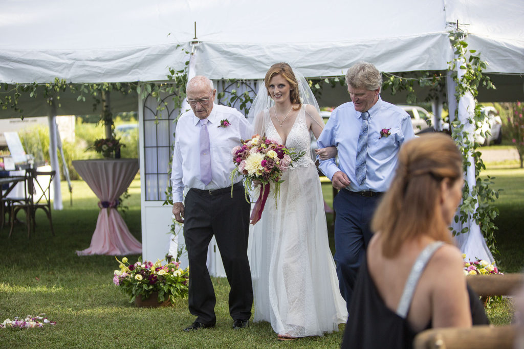 Bride, grandfather, and dad walking down the aisle