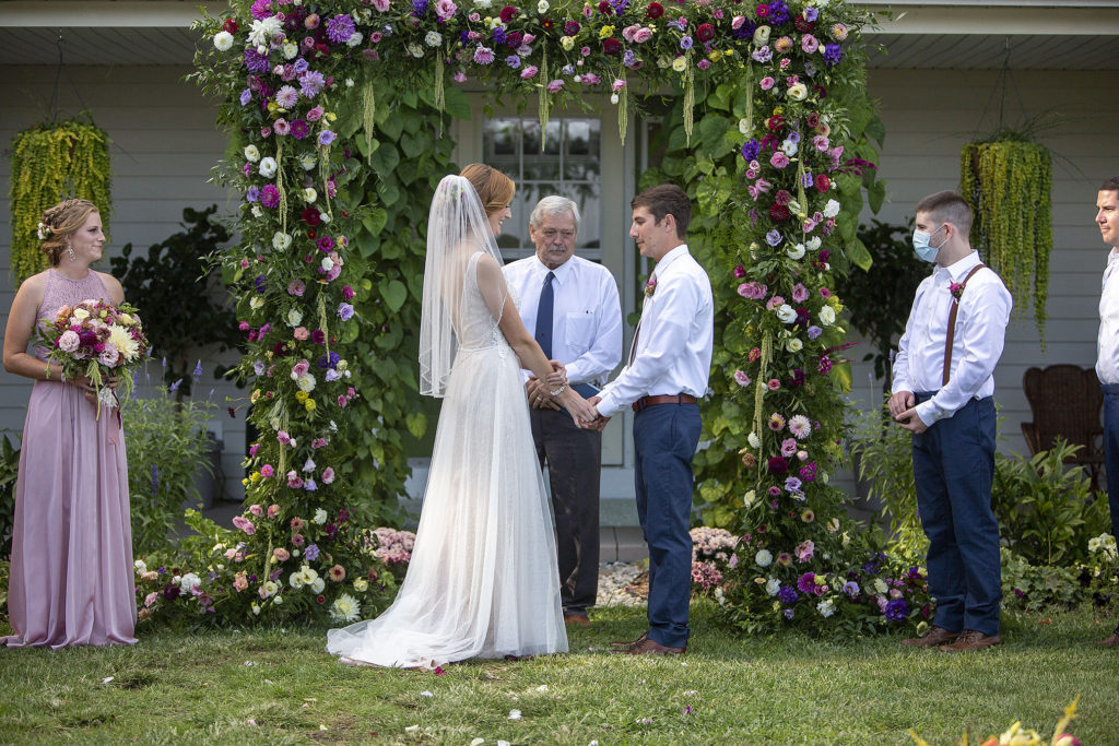 Bride and groom at floral altar