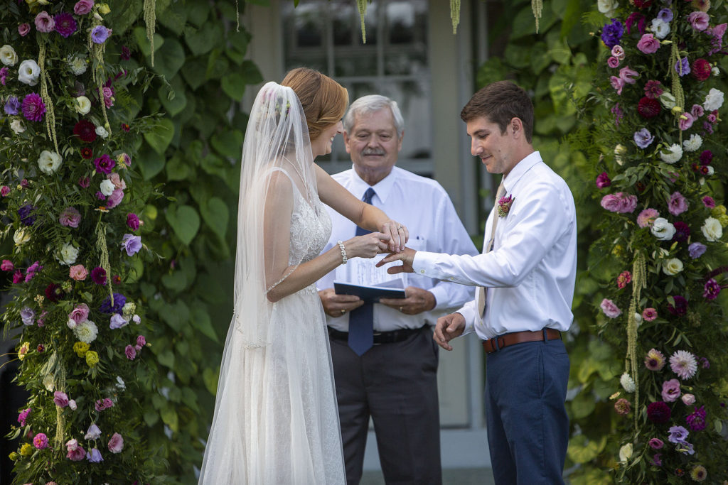 Bride puts ring on groom