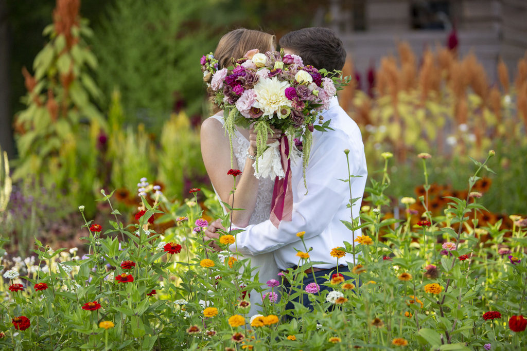 Sneaking a kiss behind Carmen's wedding bouquet