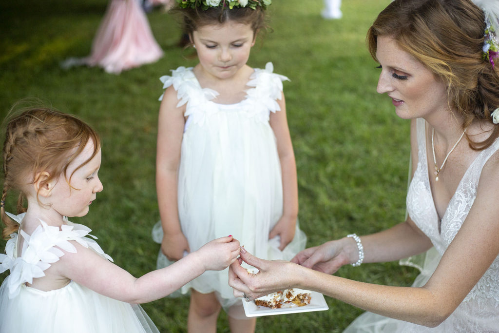 Bride sharing cake with her flower girls