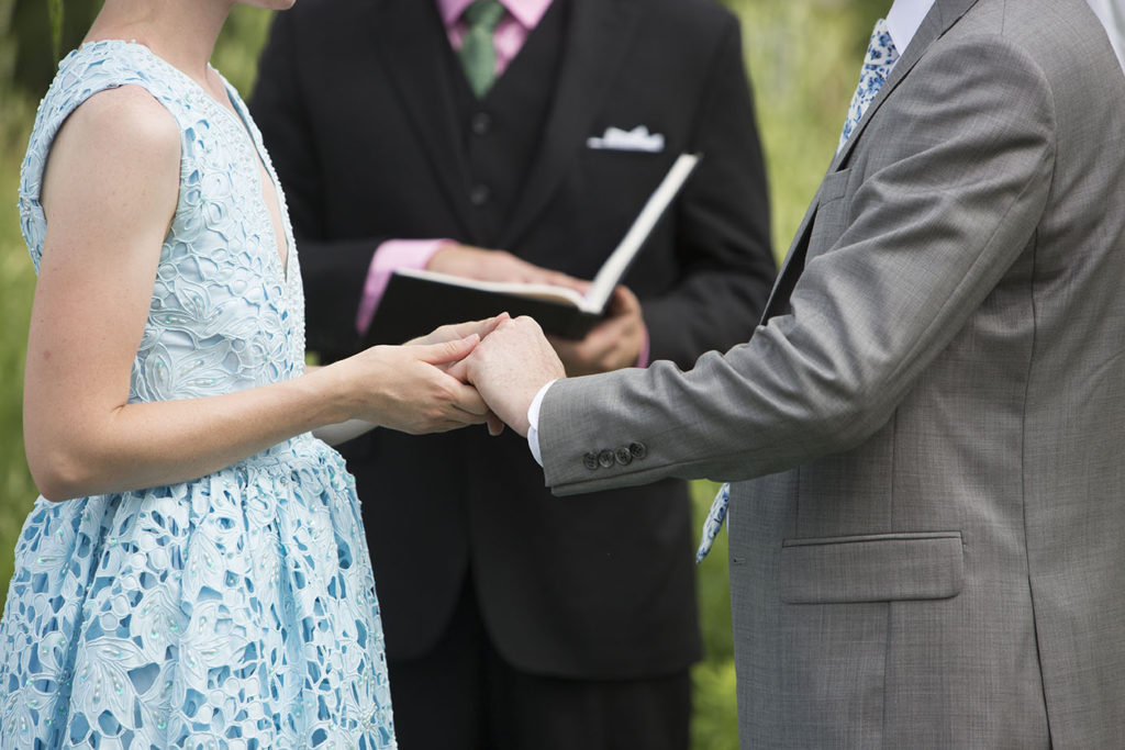 Ypsilanti couple holding hands while Michigan wedding photographer takes photos