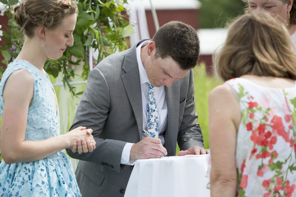 Groom signs marriage license after Ypsilanti wedding