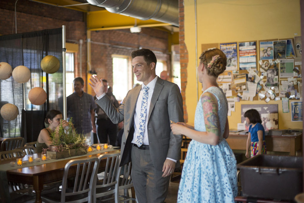 Groom waving to guests at Corner Brewery Ypsilanti wedding reception