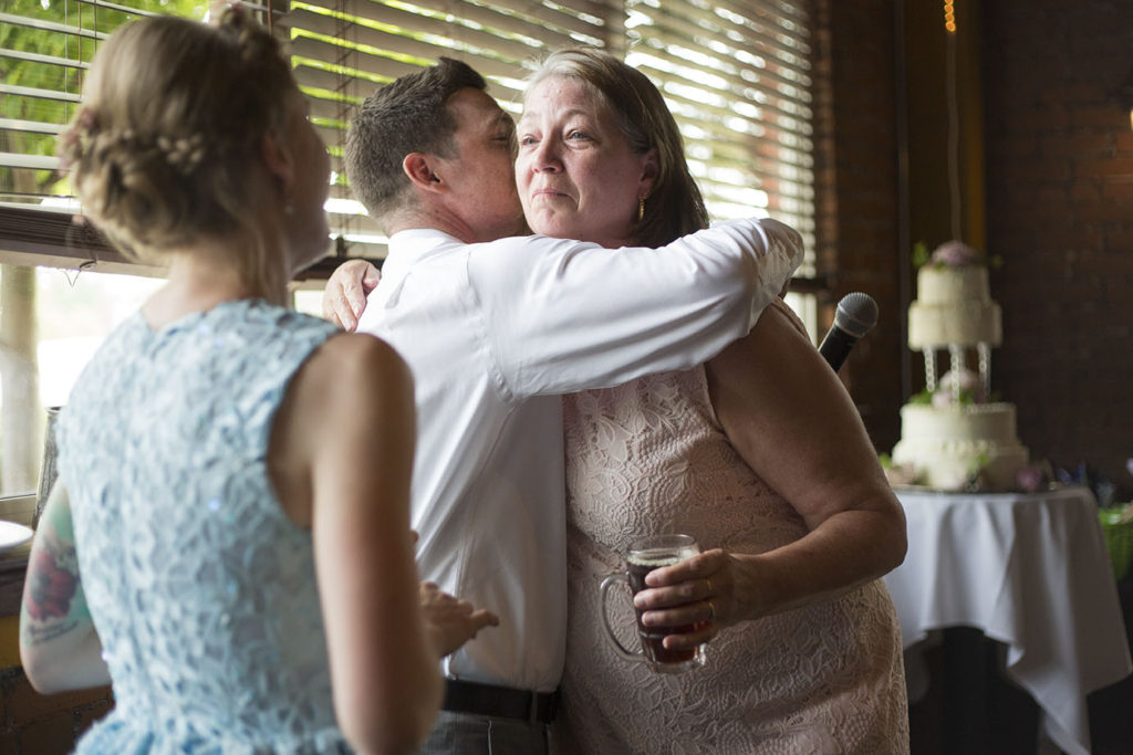 Groom hugs mother after her speech Ypsilanti wedding reception photographer