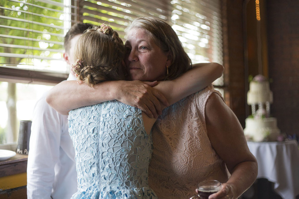 Bride hugs teary eyed mother-in-law Ypsilanti wedding photographer