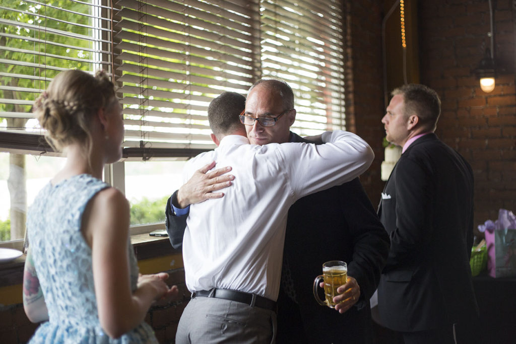 Father hugs son-in-law at Ypsilanti wedding reception