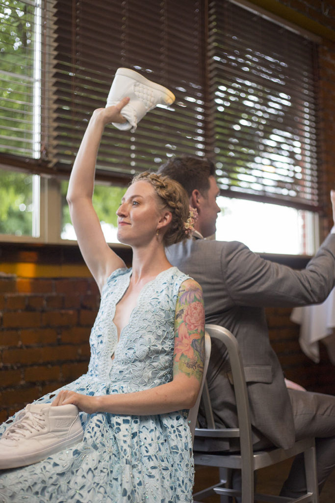 Rachel holds up shoe during "the shoe game" at Ypsilanti wedding reception