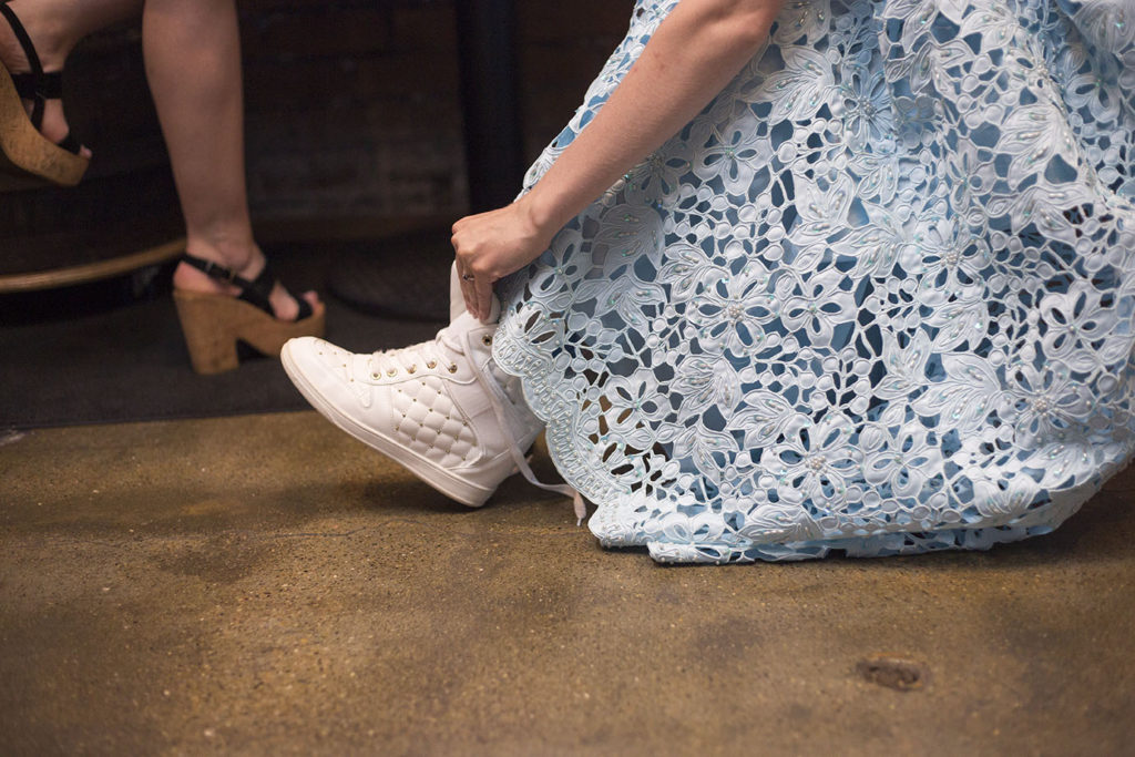 Bride ties her shoe during Ypsilanti wedding reception