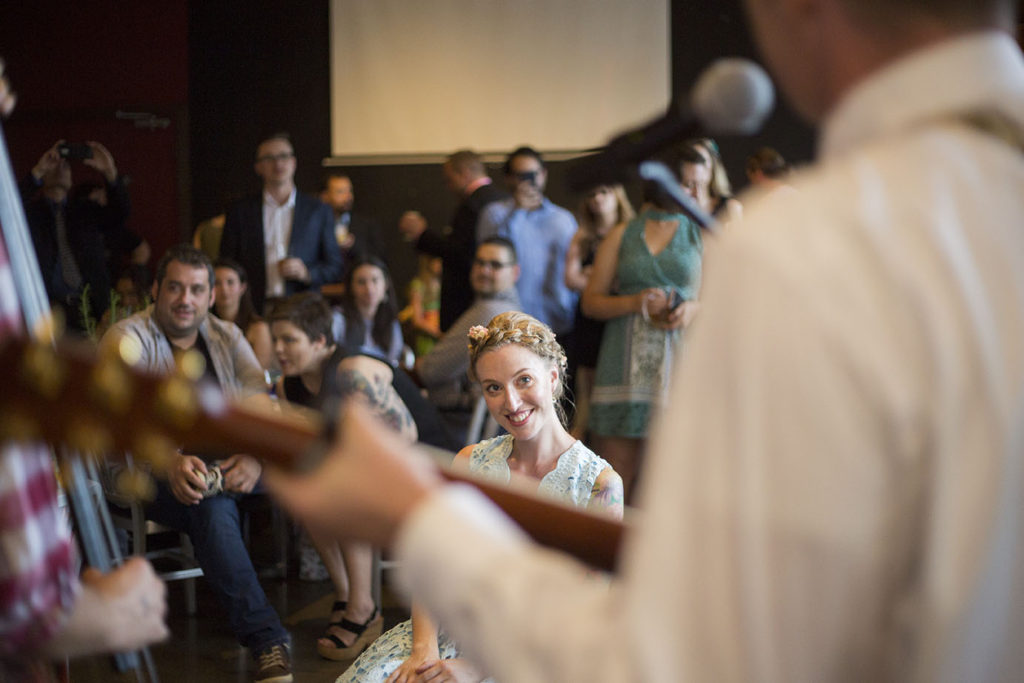 Bride over the neck of groom's guitar Ypsilanti wedding reception