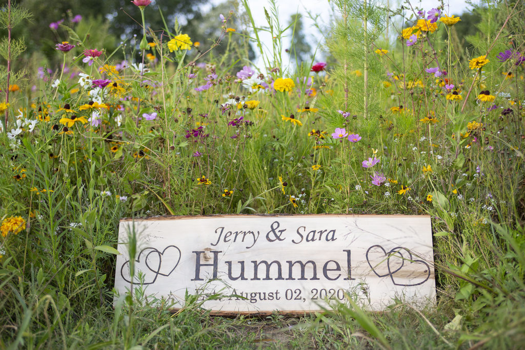 Woodburned sign in front of wildflower field