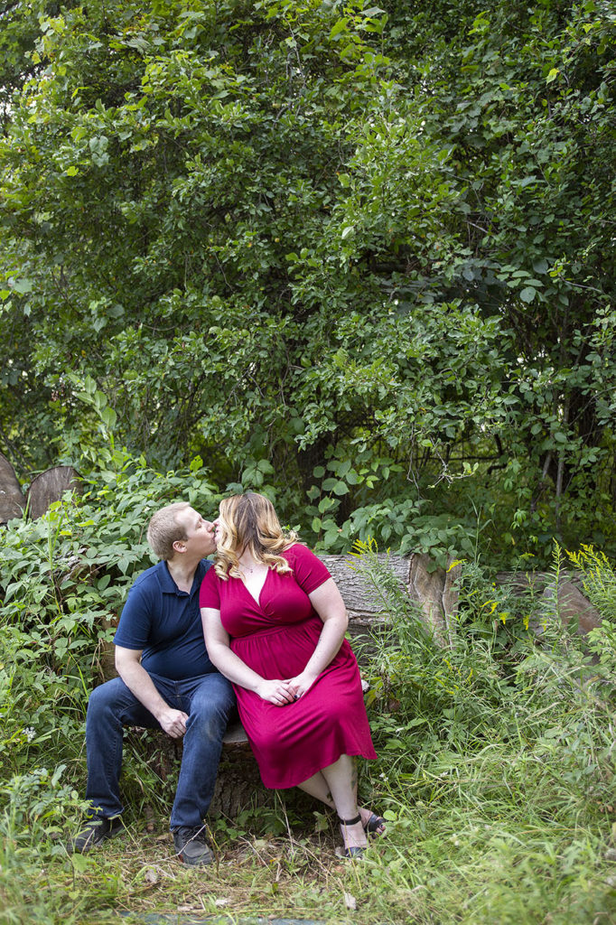 Wide angle of couple kissing on a stump