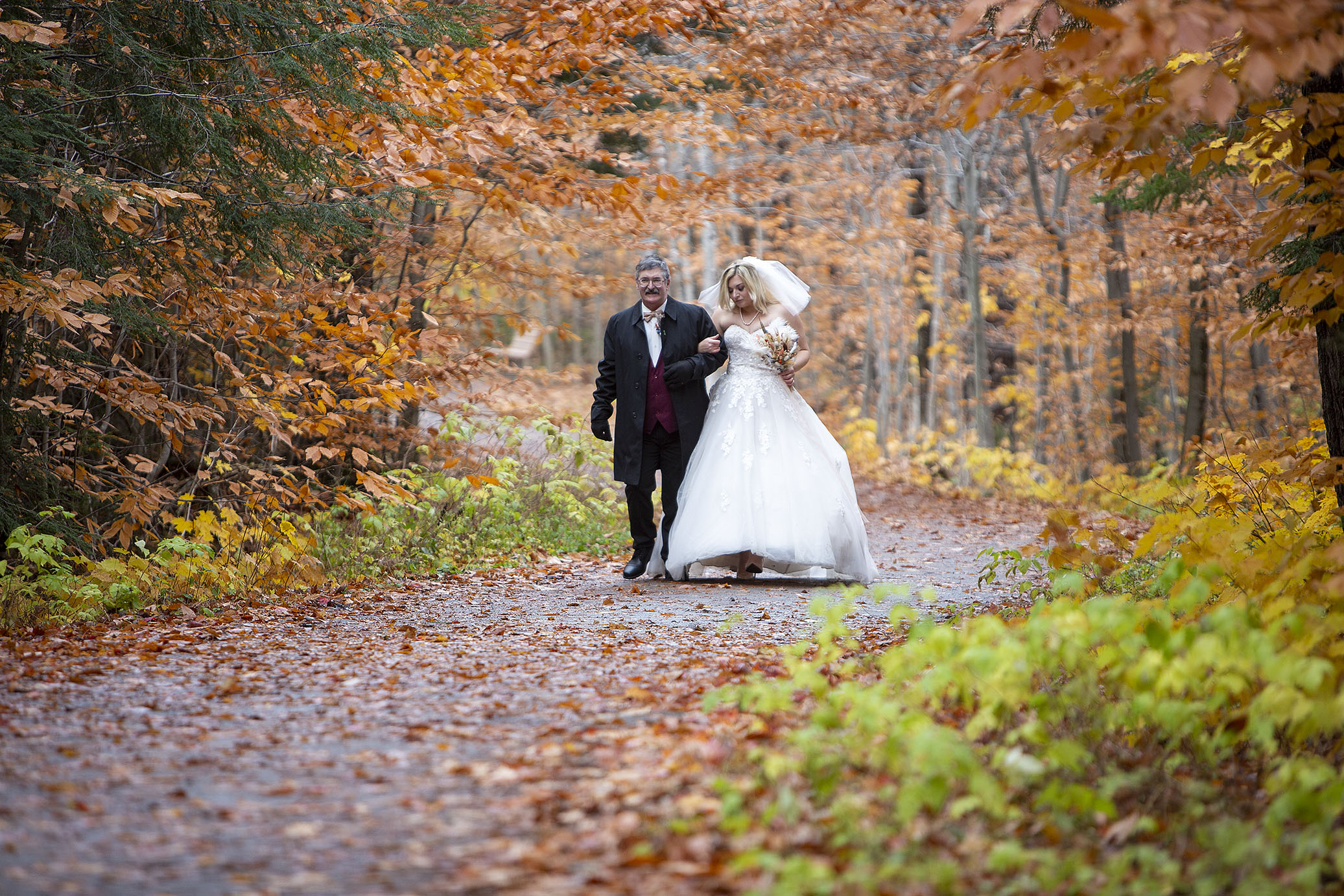 Father and bride walk together for her Tahquamenon Falls elopement