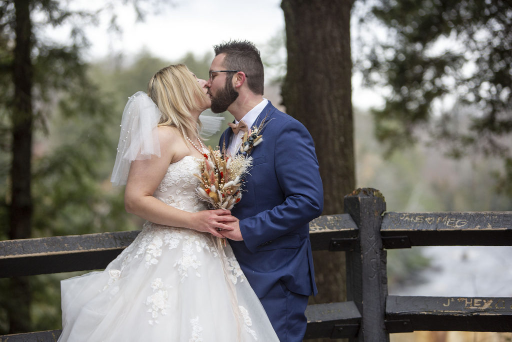 Married couple kisses at Tahquamenon Falls elopement