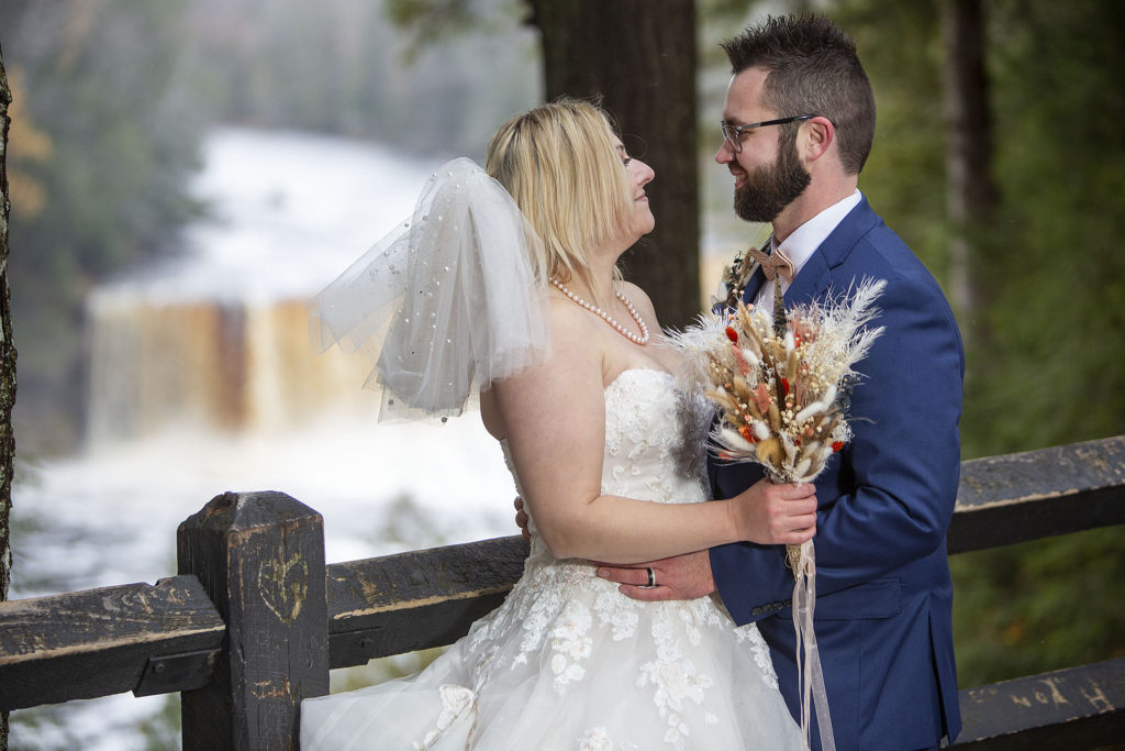 Tahquamenon Falls in the background of wedding couple