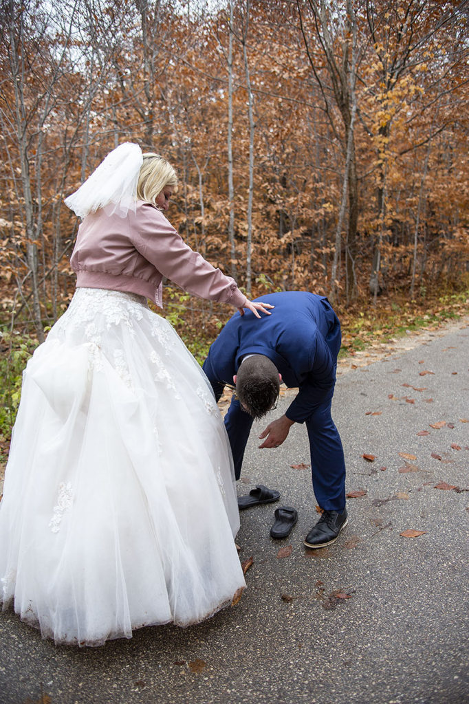 Groom helping bride switch shoes Tahquamenon Falls elopement