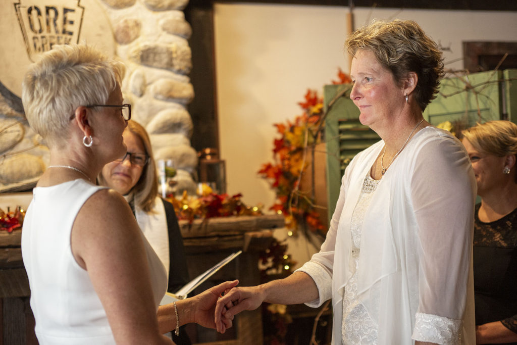 Bride holds bride's hand during vows