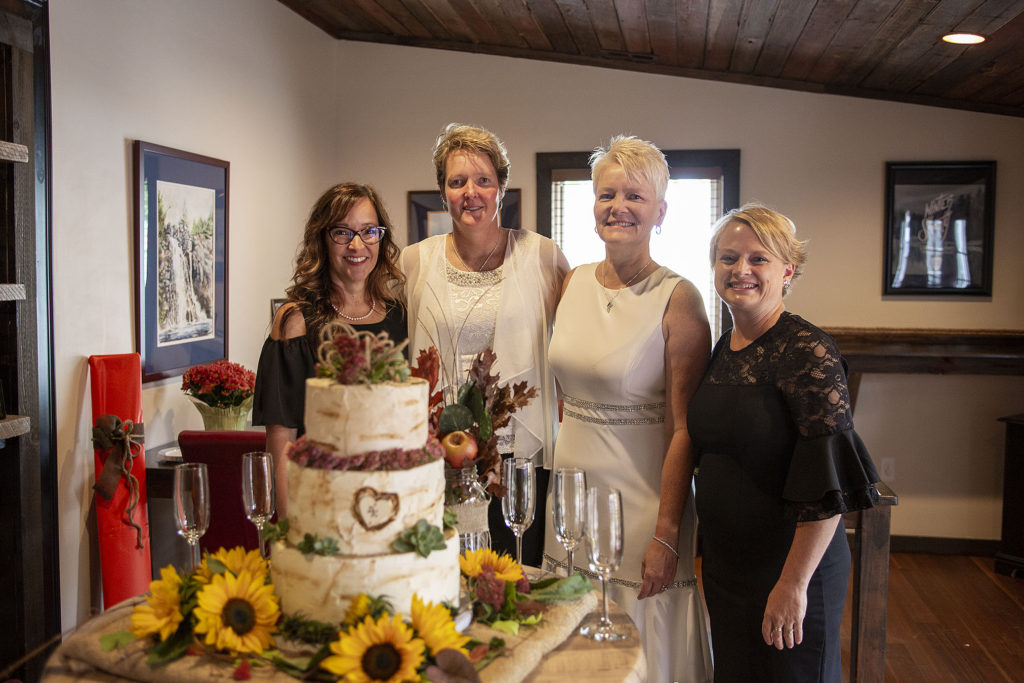 Bride and bride pose with bridesmaids