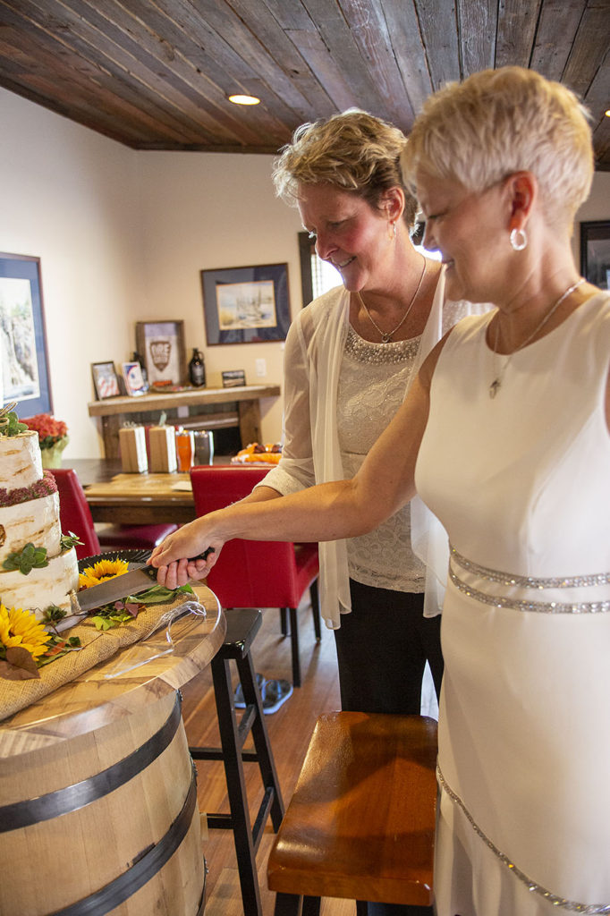 Both brides cutting the cake